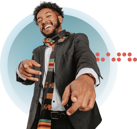 Man in dark suit jacket and colourful scarf pointing forward with hands